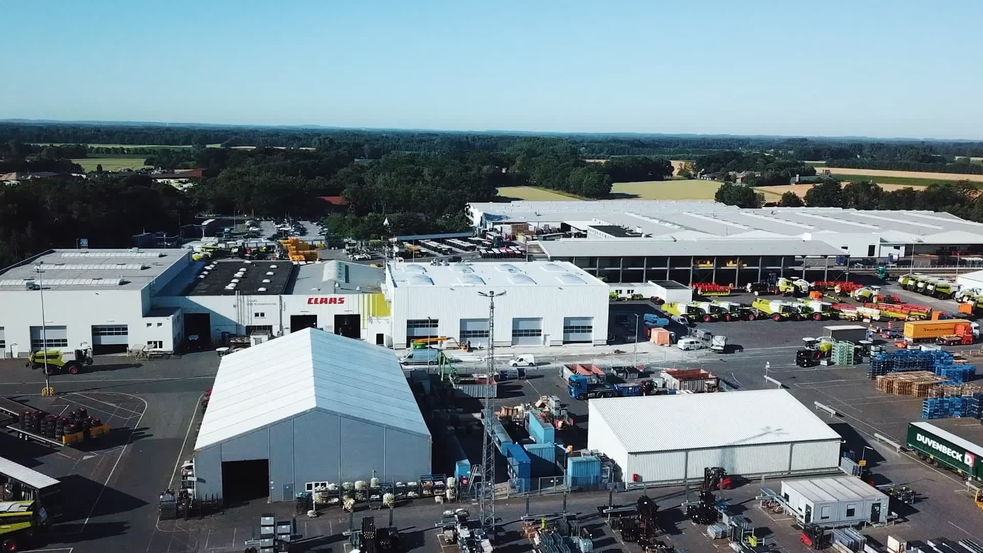 Aerial view of a CLAAS industrial complex with large buildings and outdoor farm equipment storage.